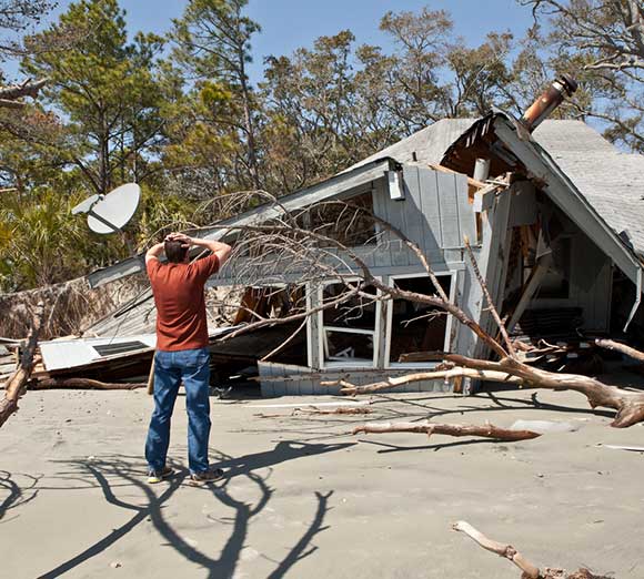 Man grieving over destroyed house